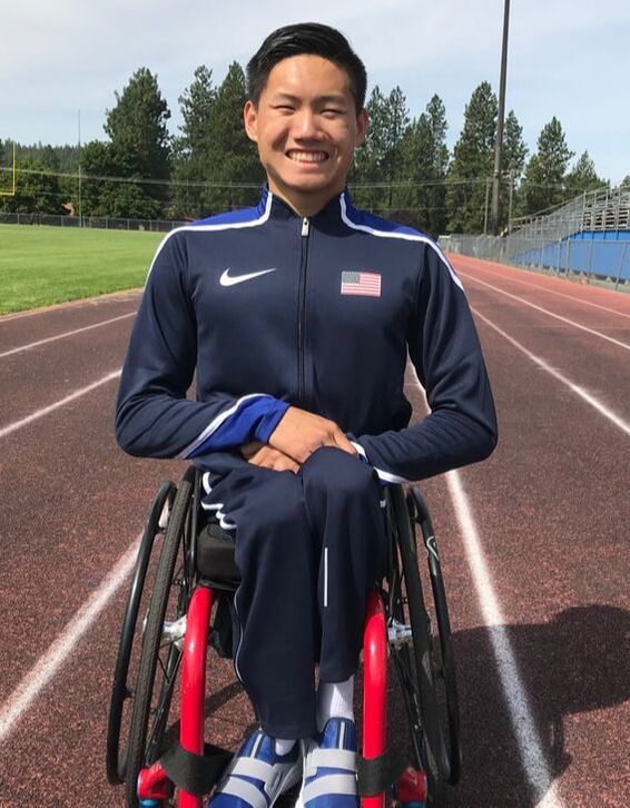 Phillip Croft in a Team USA jacket sits in a red-framed wheelchair