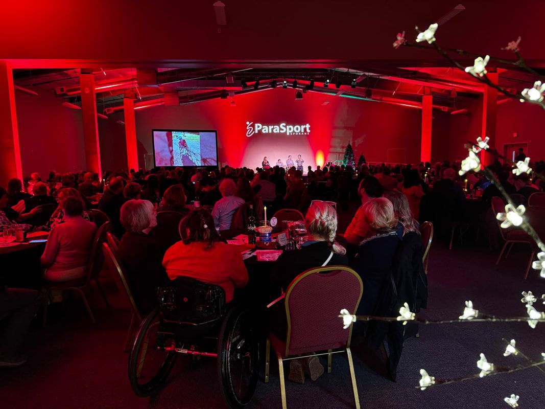 Guests fill red-lit banquet tables at the Pairing with ParaSport dinner