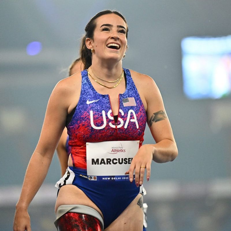 Team USA athlete with a prosthetic leg beams after her event