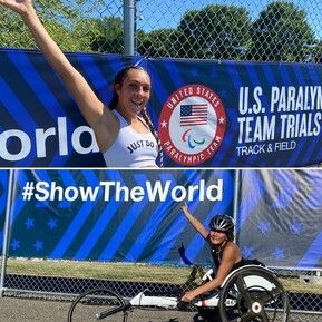 Two athletes celebrate at the U.S. Paralympic Team Trials, one in a racing chair