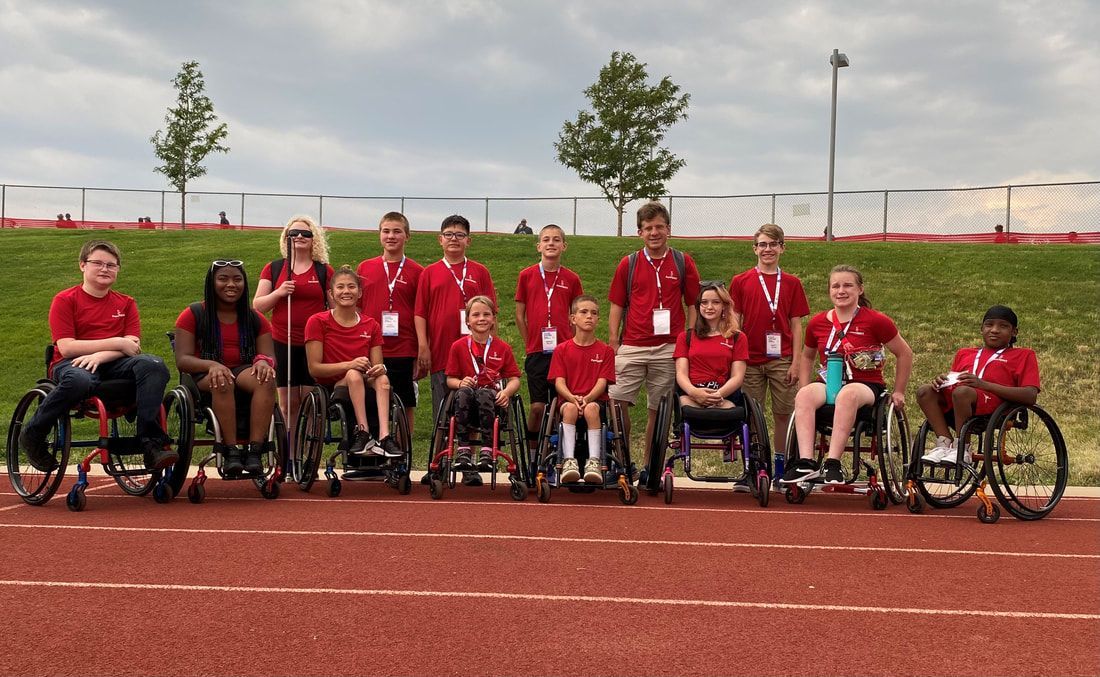 ParaSport Spokane athletes in red shirts pose on the track at Junior Nationals