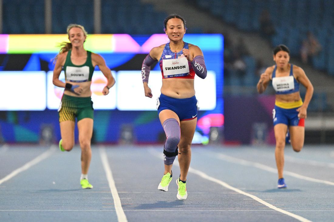 Team USA sprinter leads two rivals down the track toward the camera