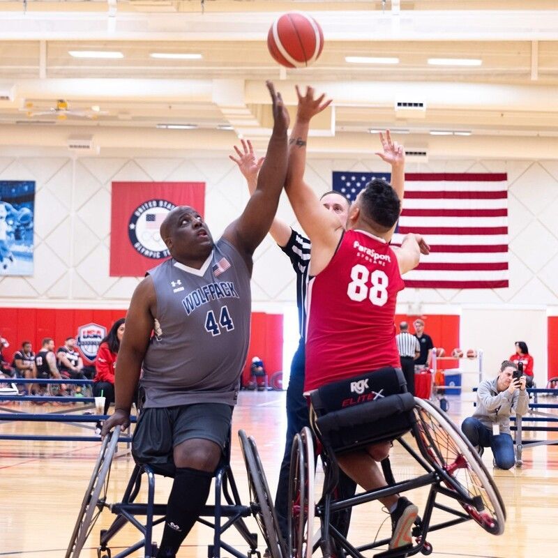 Tip-off between player #88 in red and #44 in gray as the referee looks on