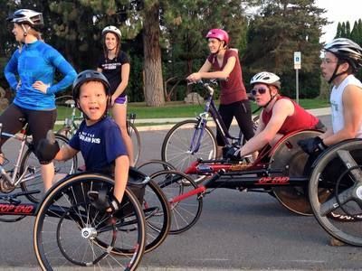 Smiling young racer waits with other racers and cyclists before a ride