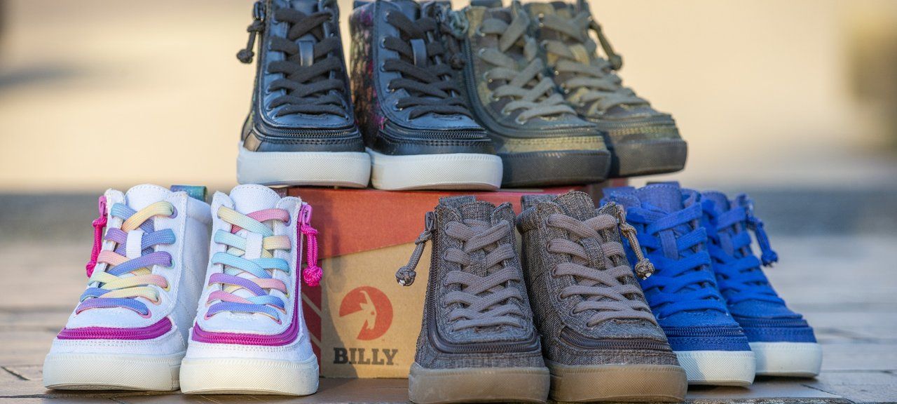 Pairs of BILLY Footwear high-top sneakers stacked around a shoebox