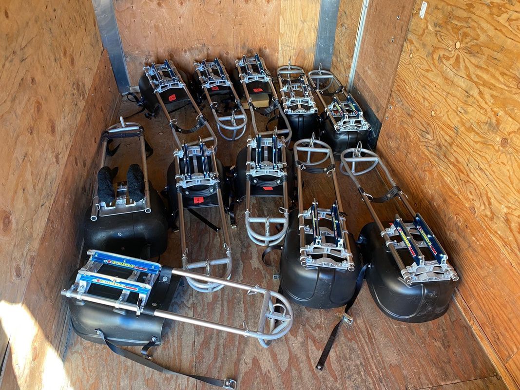 Sled hockey sleds stacked in a wooden storage box