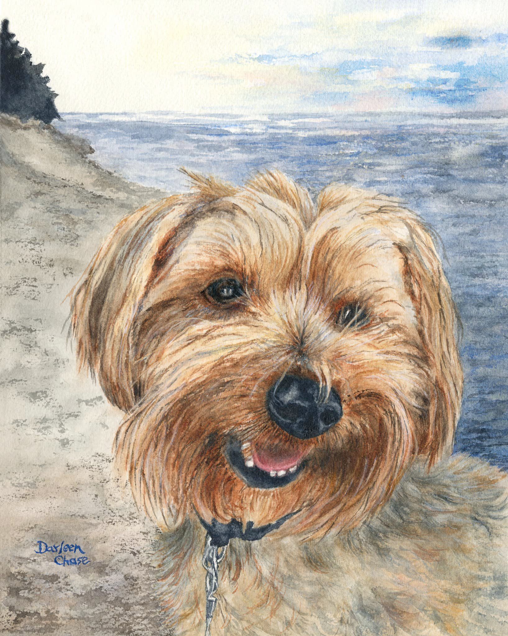 Small tan dog portrait on a beach, with blue water and sky in the background.