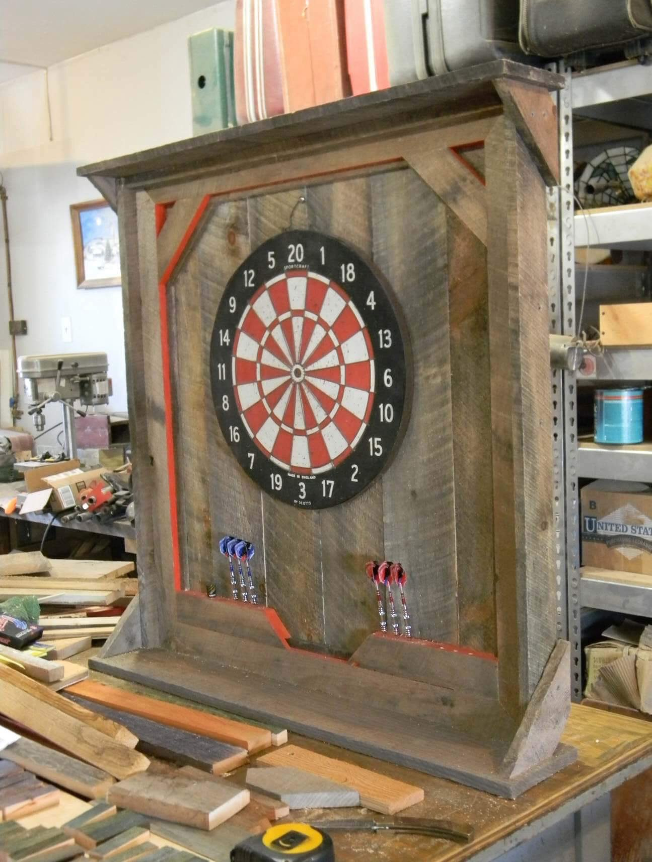 Dartboard mounted on a weathered wooden cabinet in a workshop, Woodworking by Ron Archer