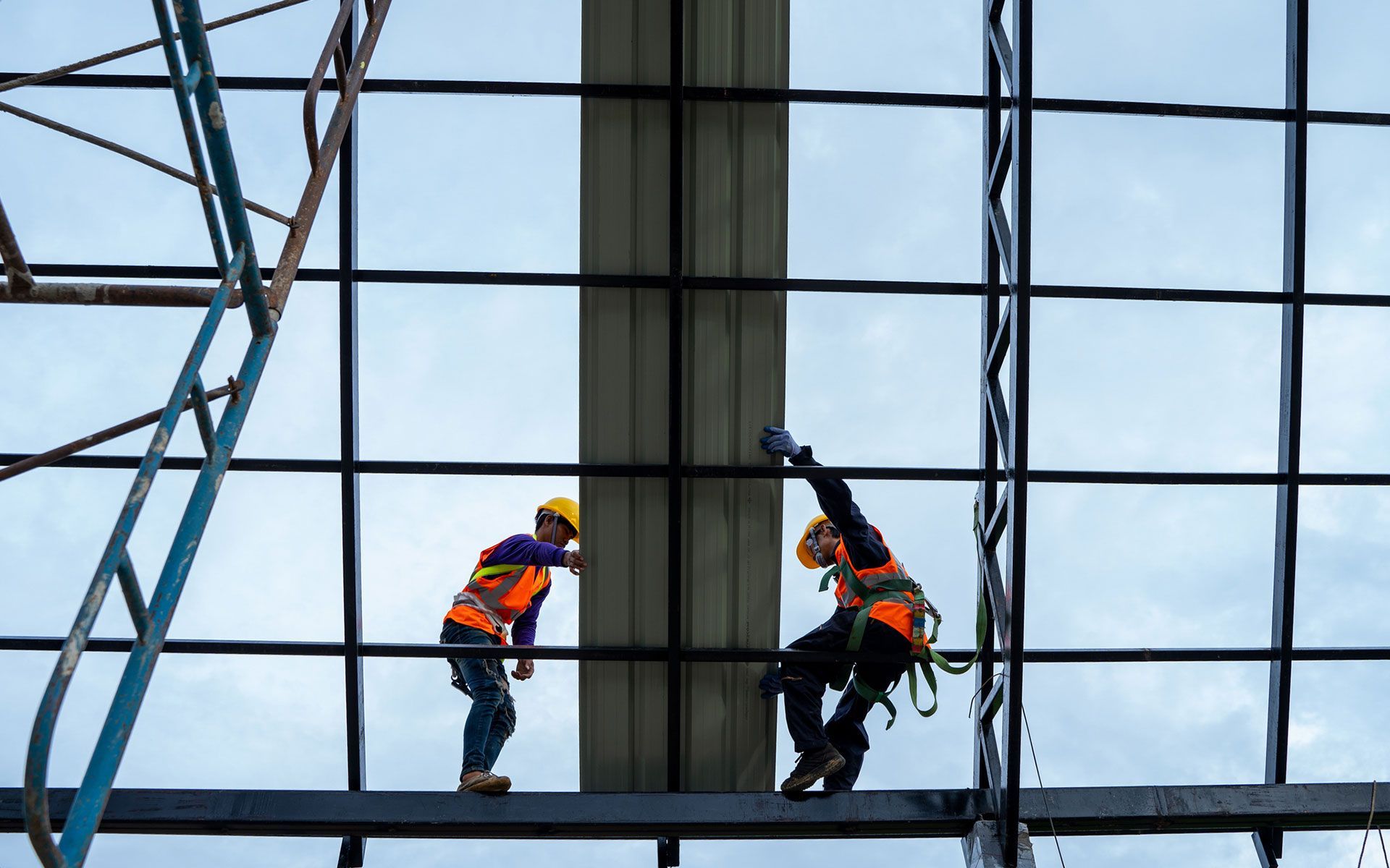 A couple of construction workers are working on a building.