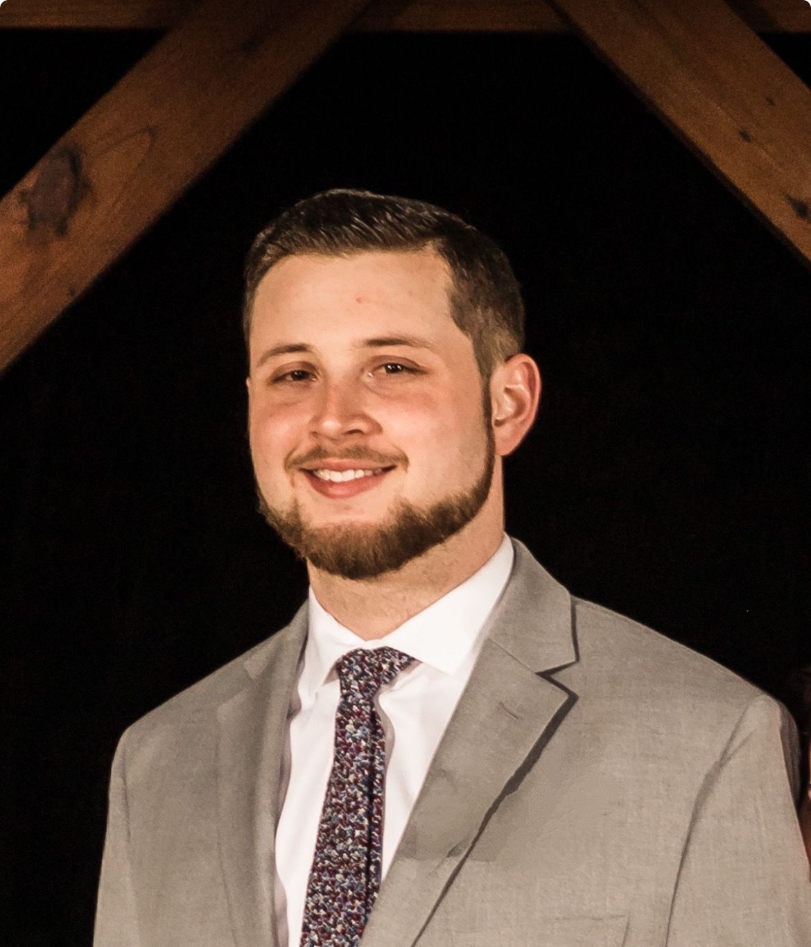 A man in a suit and tie is smiling for the camera