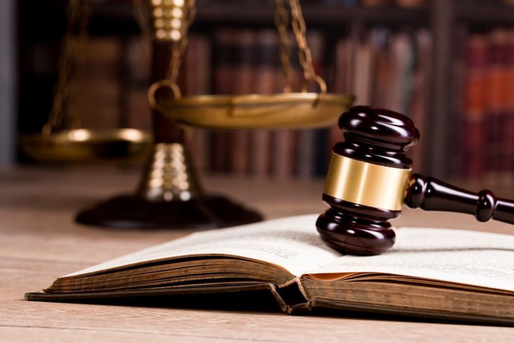 A Judge's Gavel is Sitting on Top of an Open Book — Olympus Lawyers In Ballarat Central, VIC