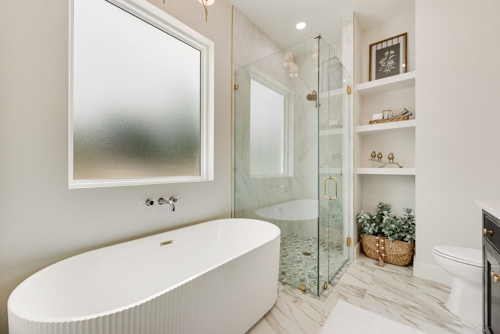 Modern bathroom with a white tub, glass shower, and built-in shelves.
