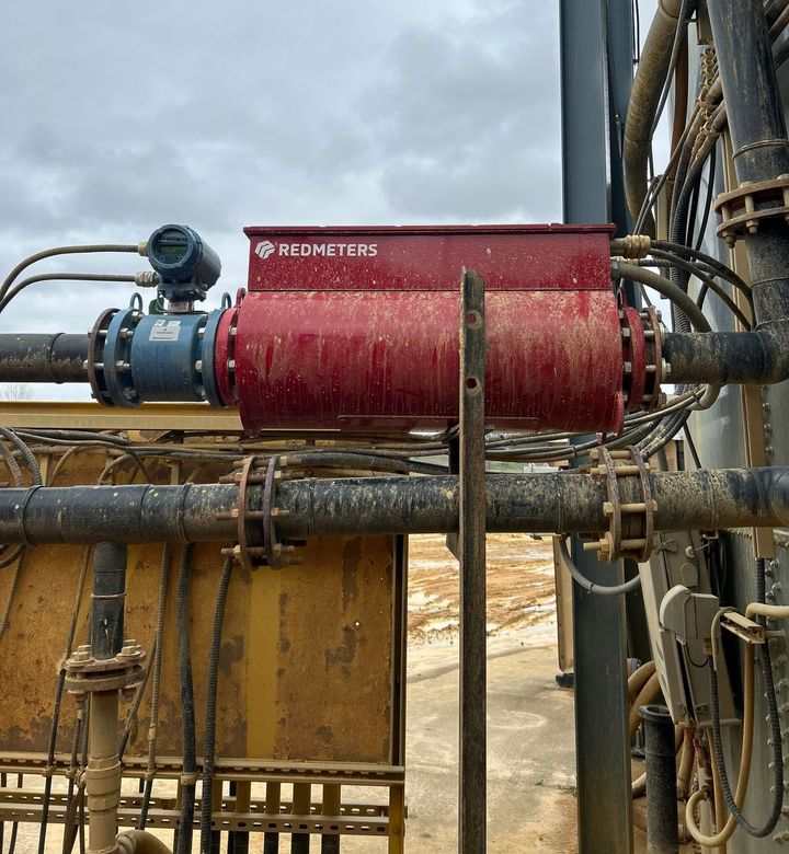 Red Rotometers box with connected pipes, instrumentation, and wiring at an industrial site. Dusty exterior.