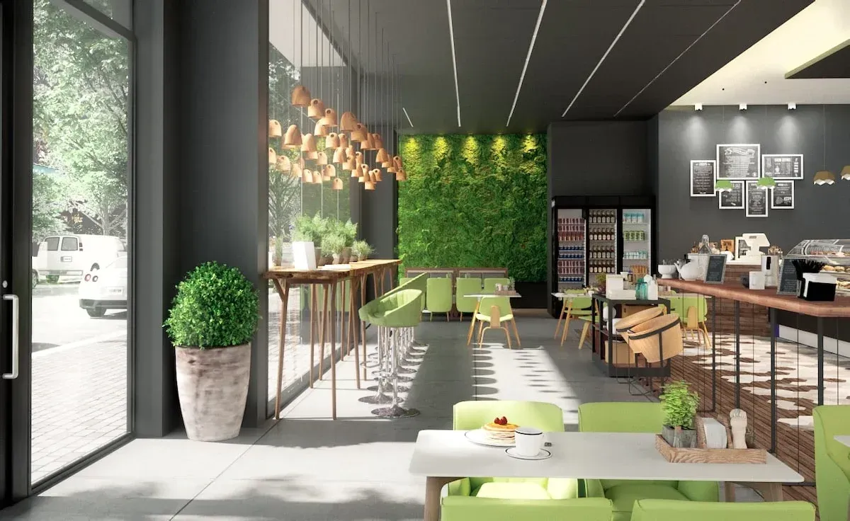Modern café interior with green decor, bar seating, hanging lights, and tables by large windows