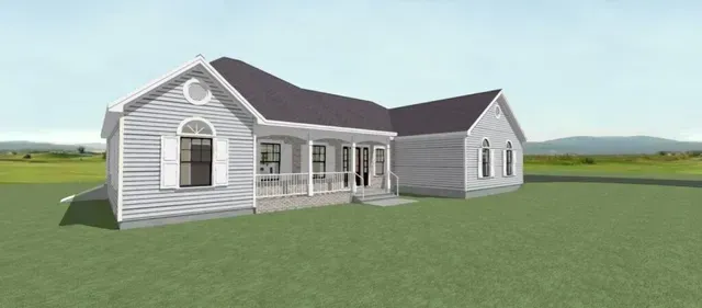 White farmhouse-style house with gray roof on a grassy field under a clear sky