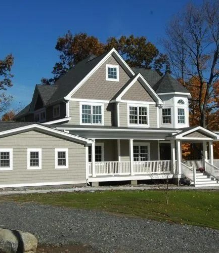 Gray two-story house with white trim, front porch, and attached garage on a sunny day