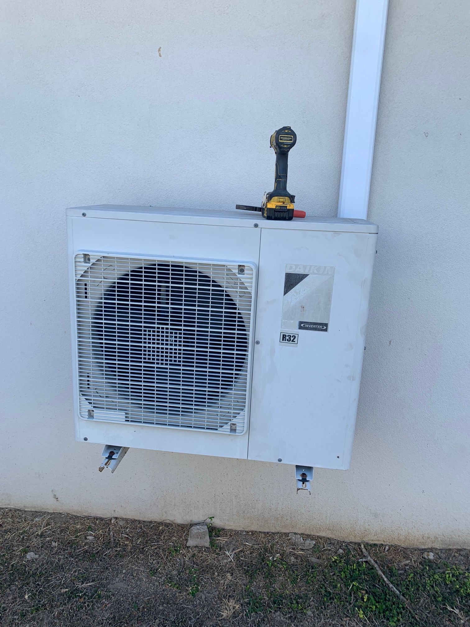 A Drill is sitting on top of a white air Conditioner - SIC Airconditioning & Refrigeration in Townsville