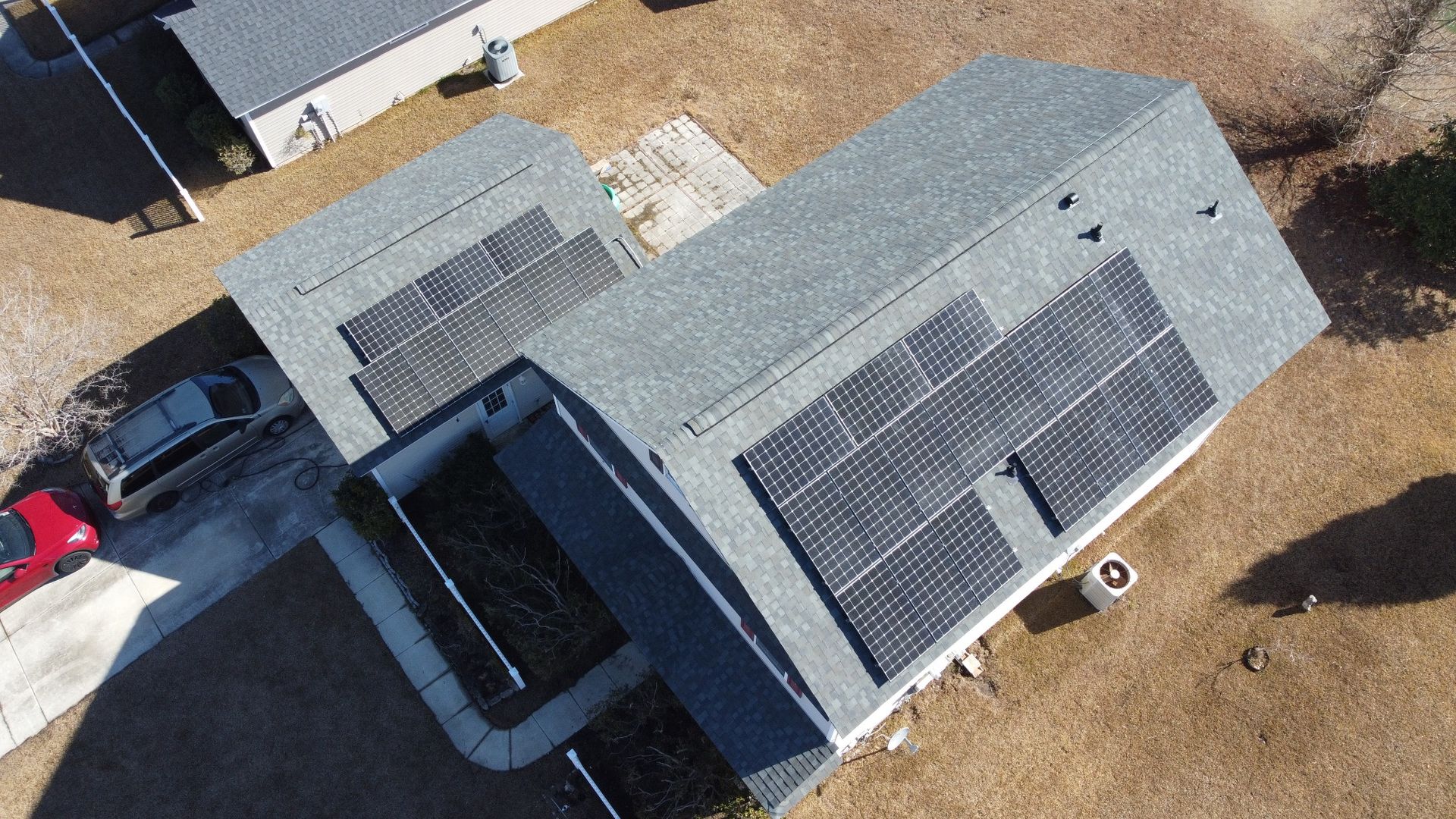 Finished light gray shingle roof on a Charleston-area home with solar panels