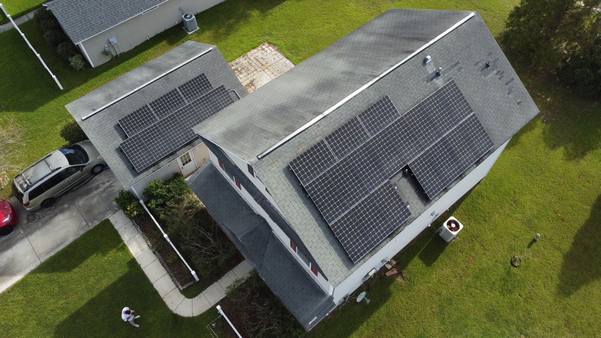 Home with solar panels and old shingles before replacement