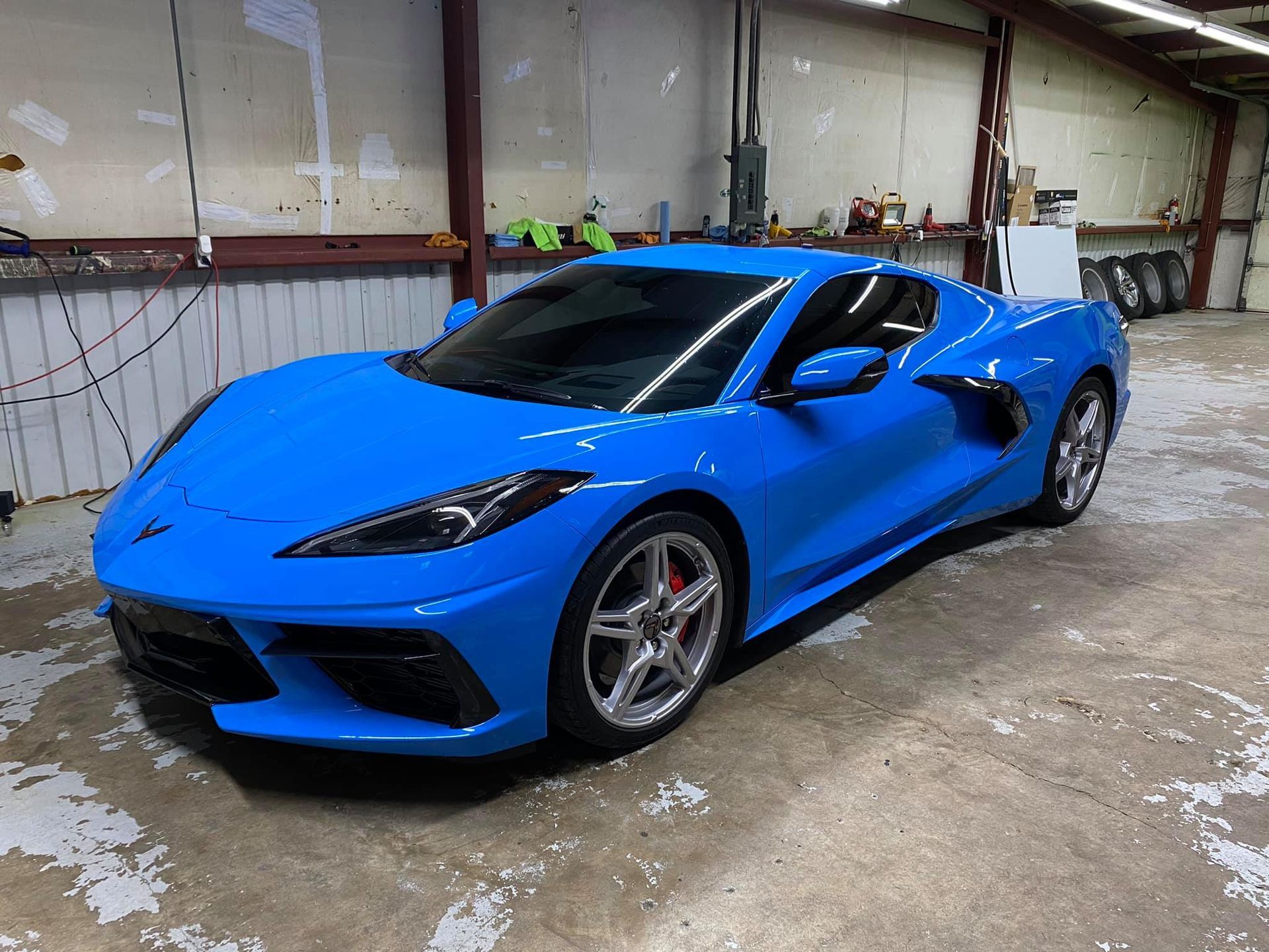 Bright blue sports car parked in a garage, front-left view