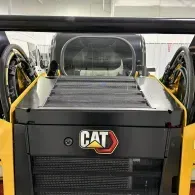 Front view of a yellow CAT industrial machine with black panels and cab interior visible