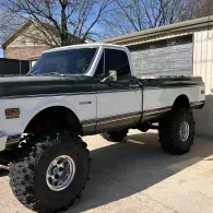 Lifted vintage two-tone pickup truck parked in a driveway