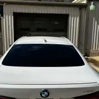 White BMW parked in front of a garage with a closed door