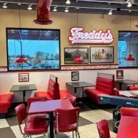 Freddy’s diner interior with red booths, retro decor, and wall-mounted TVs