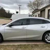 Silver sedan parked beside a garage in a driveway