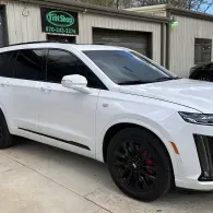 White SUV parked outside an auto shop.