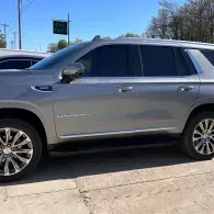 Silver SUV parked outdoors on a sunny day, side view