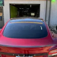Red sedan parked at an auto shop garage entrance