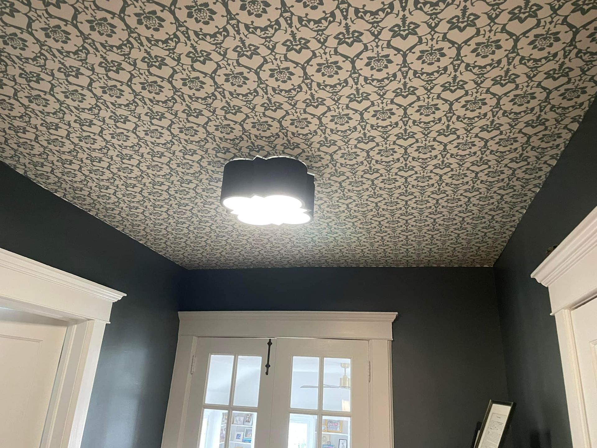 A hallway with a light on the ceiling and a door.