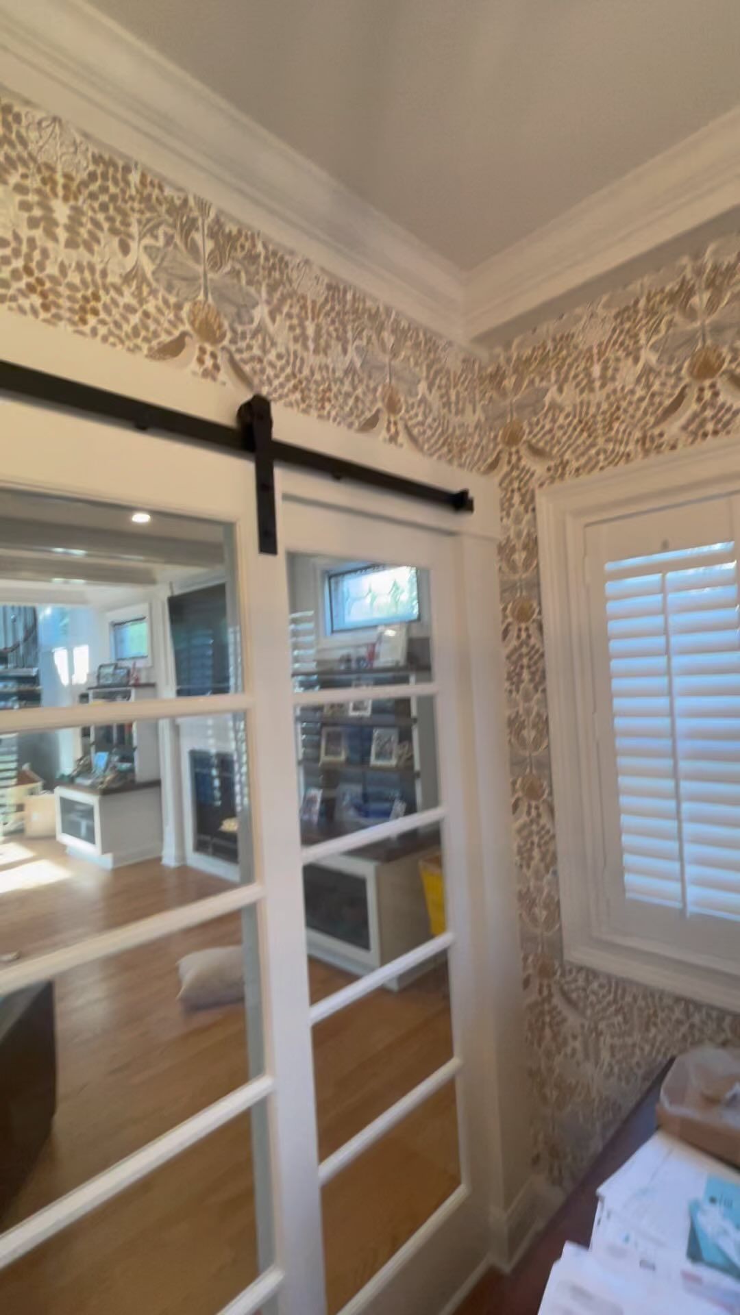 A room with sliding glass doors and shutters on the windows.