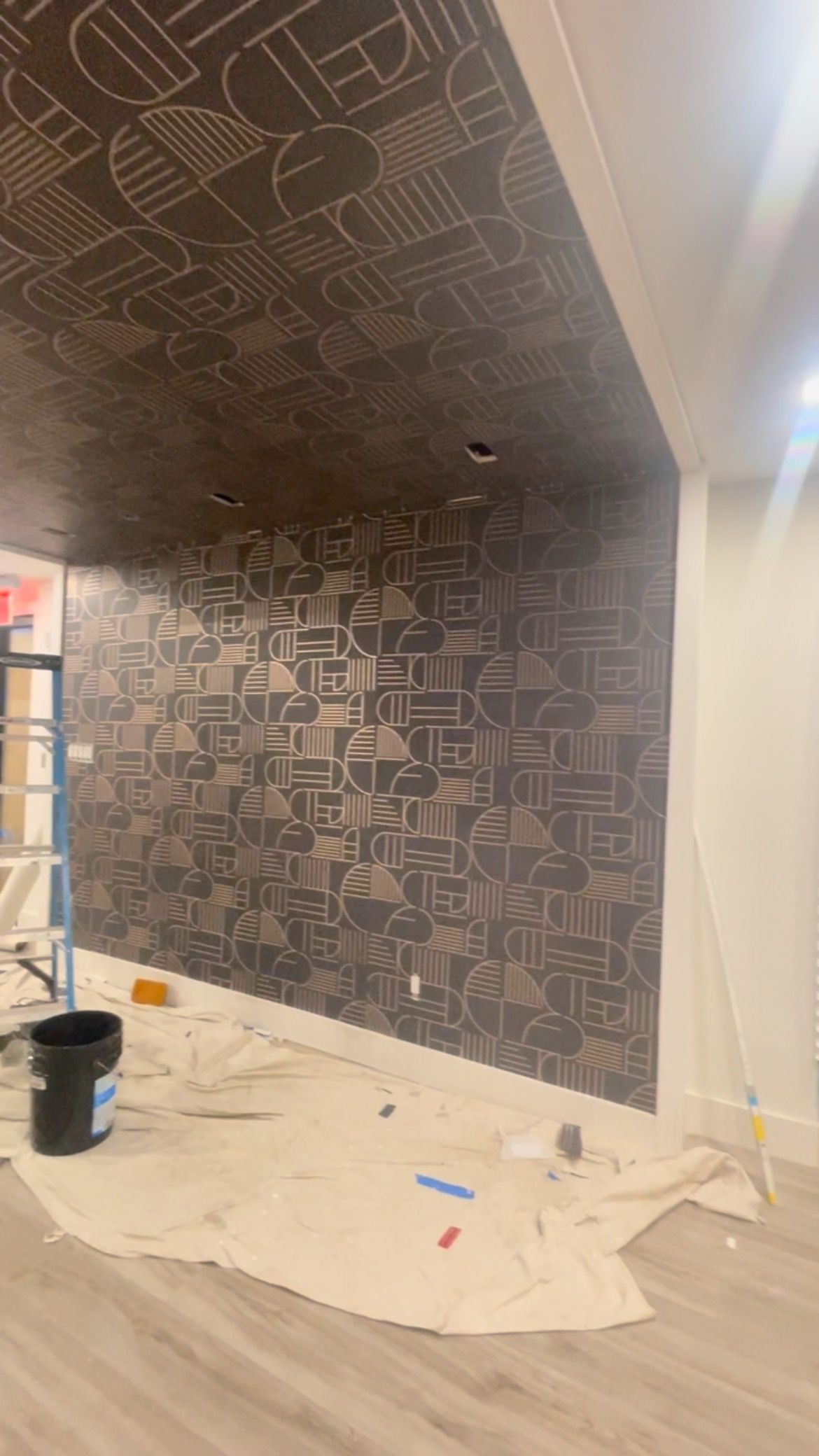 A room with a ceiling that is being painted and a wall that is being painted.