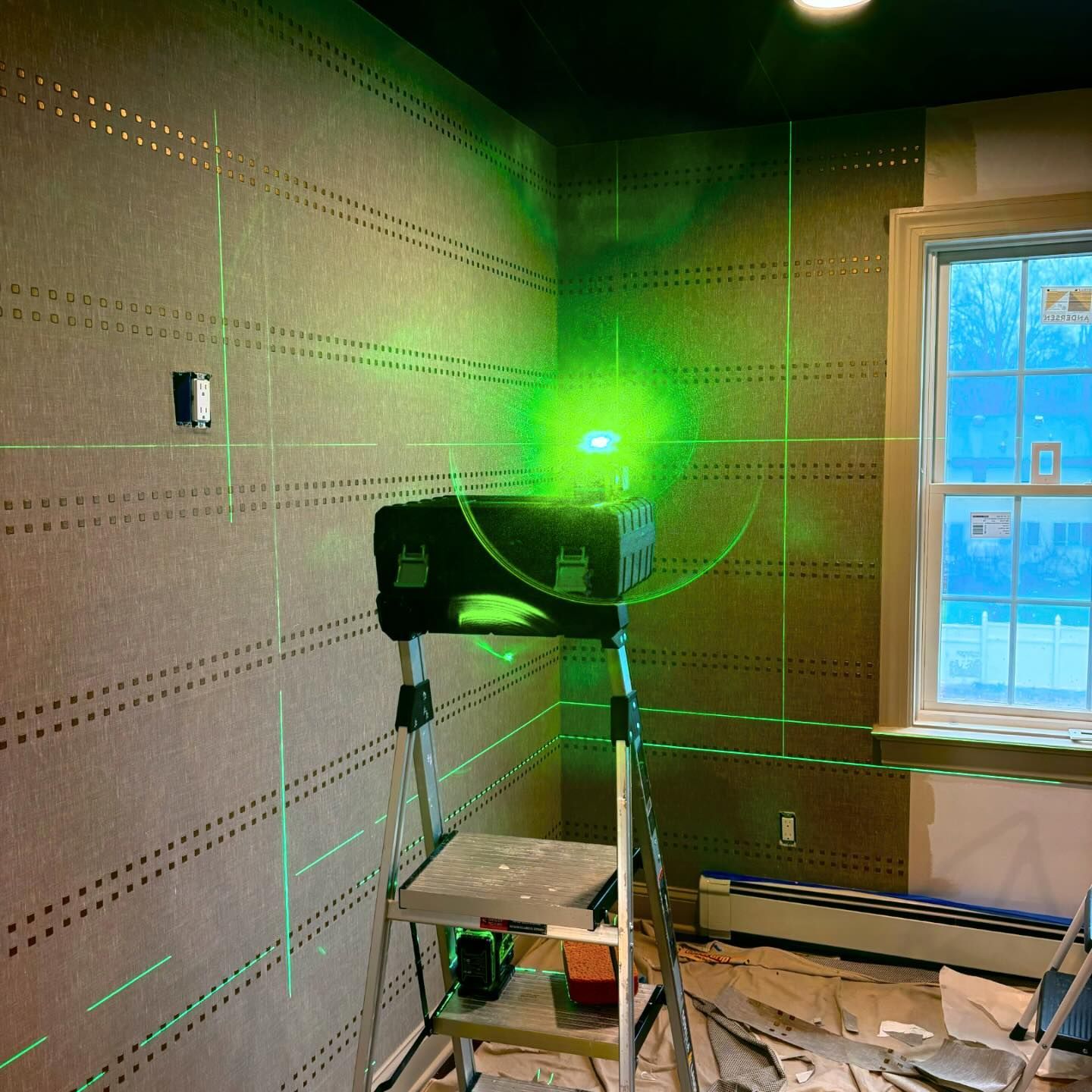 A green light is shining on a wall in a room