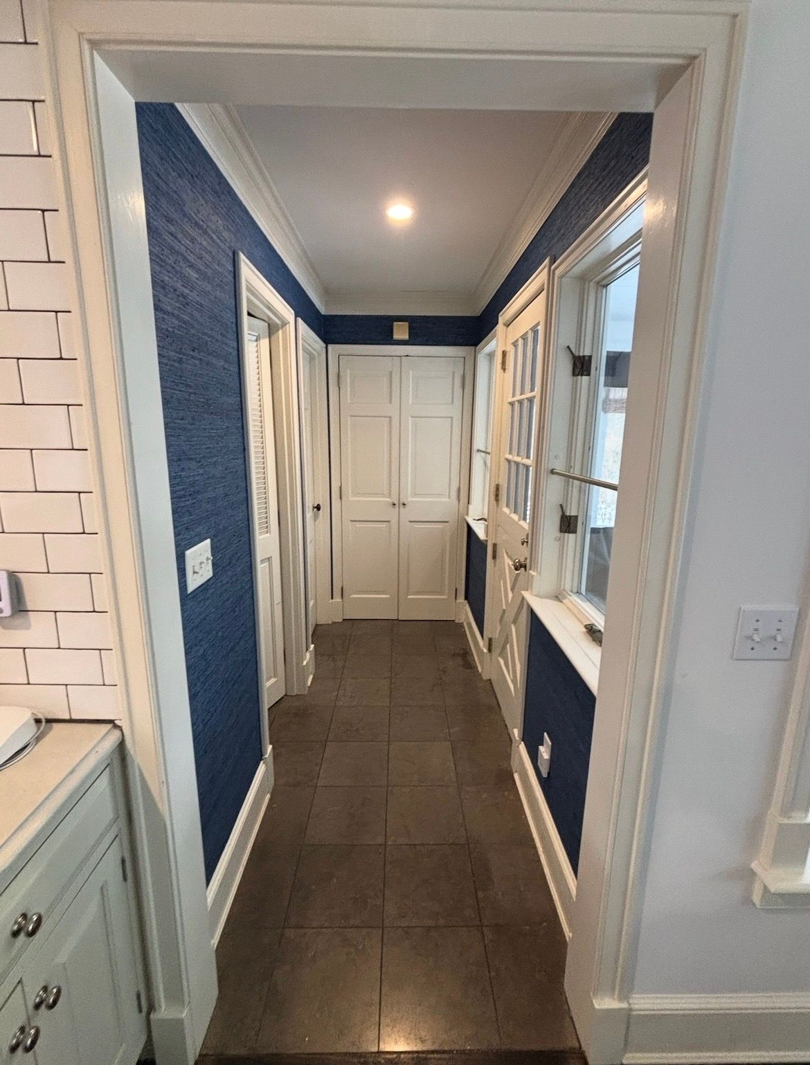 A ladder is sitting in front of a door in a room with a ceiling.