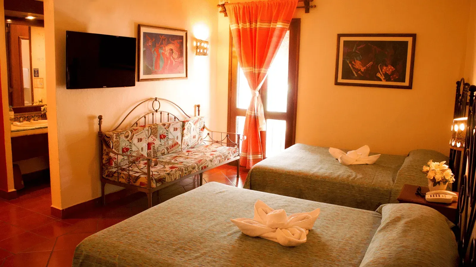 Una habitación de hotel con dos camas con toallas blancas dobladas.