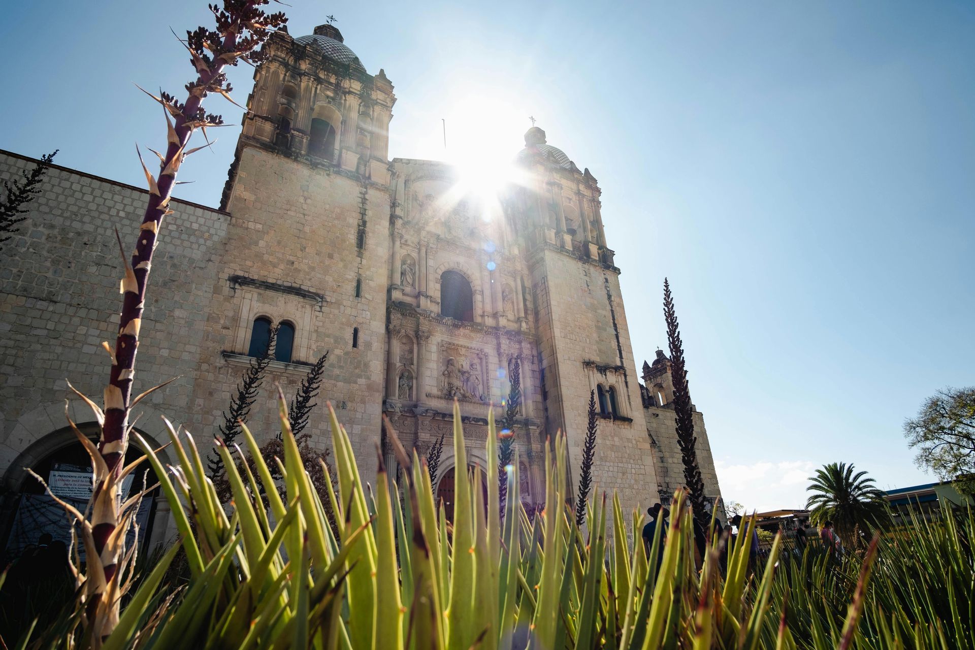 La luz del sol se filtra tras las ornamentadas torres de piedra de una iglesia de estilo colonial.