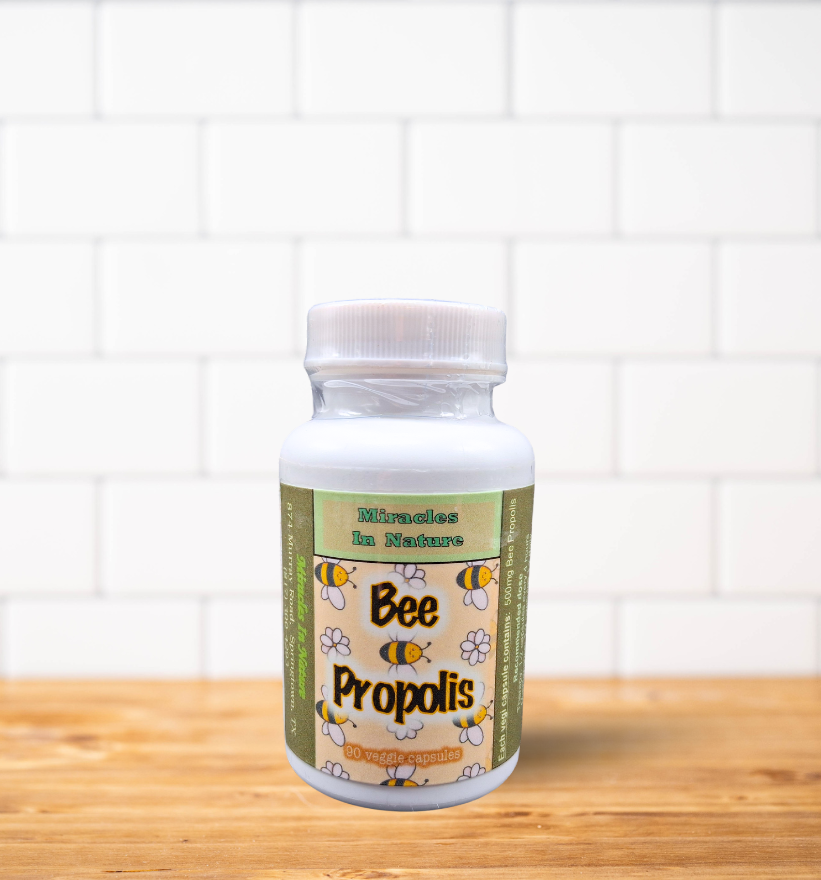 A bottle of bee propolis is sitting on a wooden table