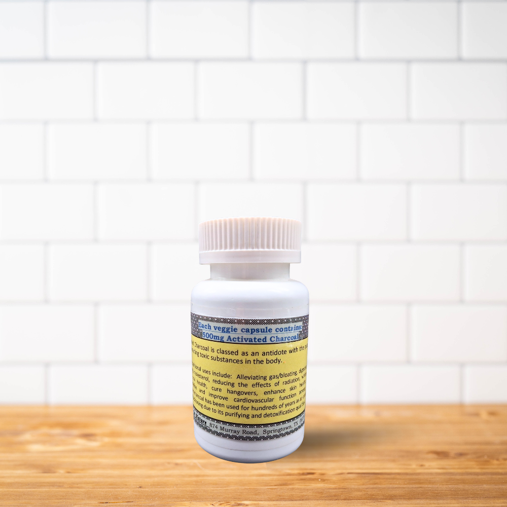 A bottle of pills is sitting on a wooden table in front of a white brick wall.