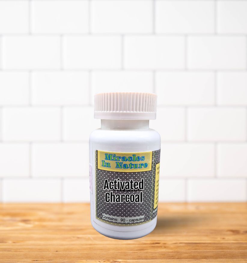 A bottle of activated charcoal is sitting on a wooden table.