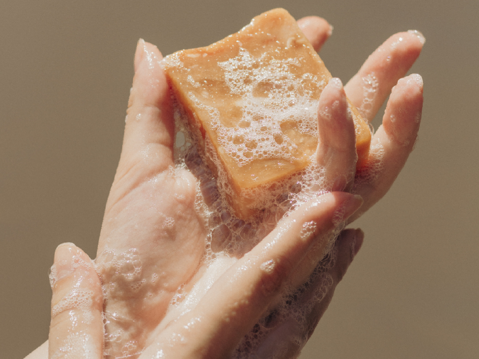 A person is holding a piece of soap in their hand.