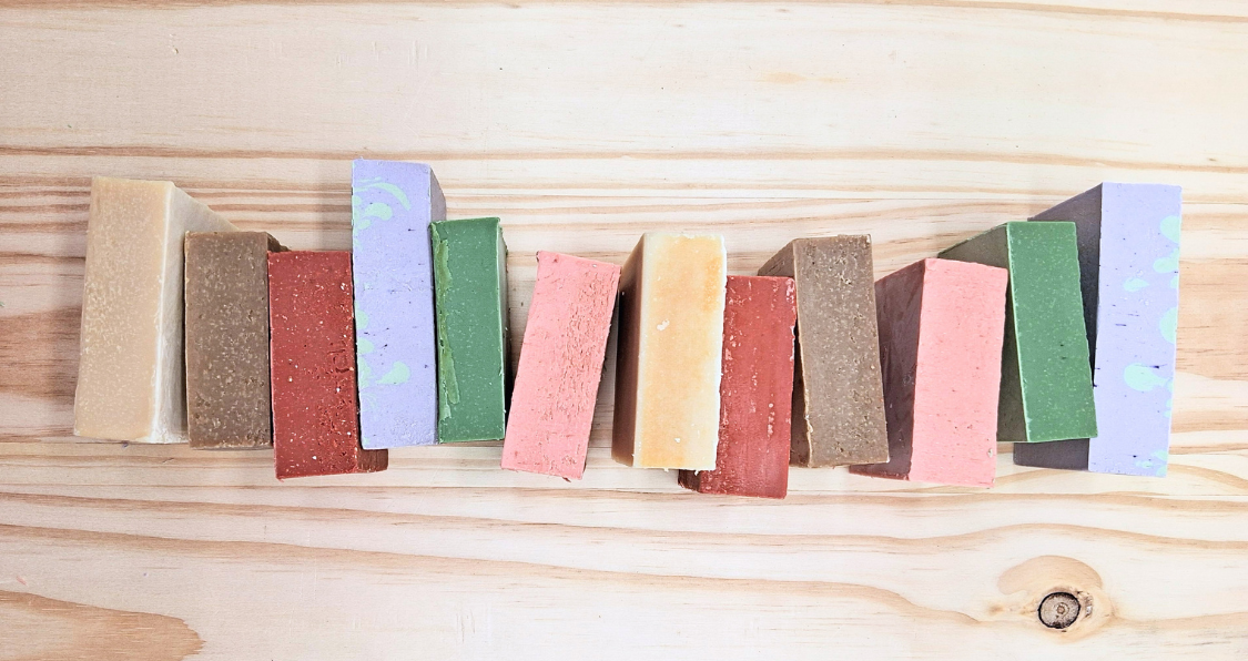 A row of colorful soap bars sitting on top of a wooden table.