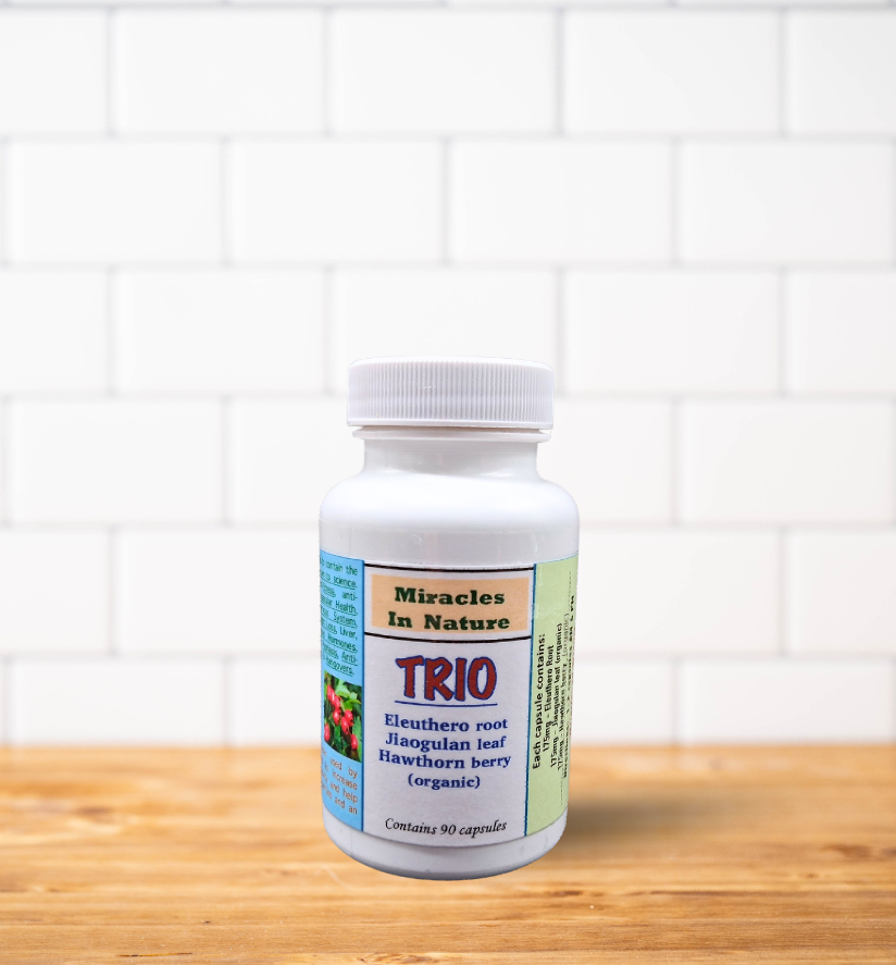A bottle of trio is sitting on a wooden table.