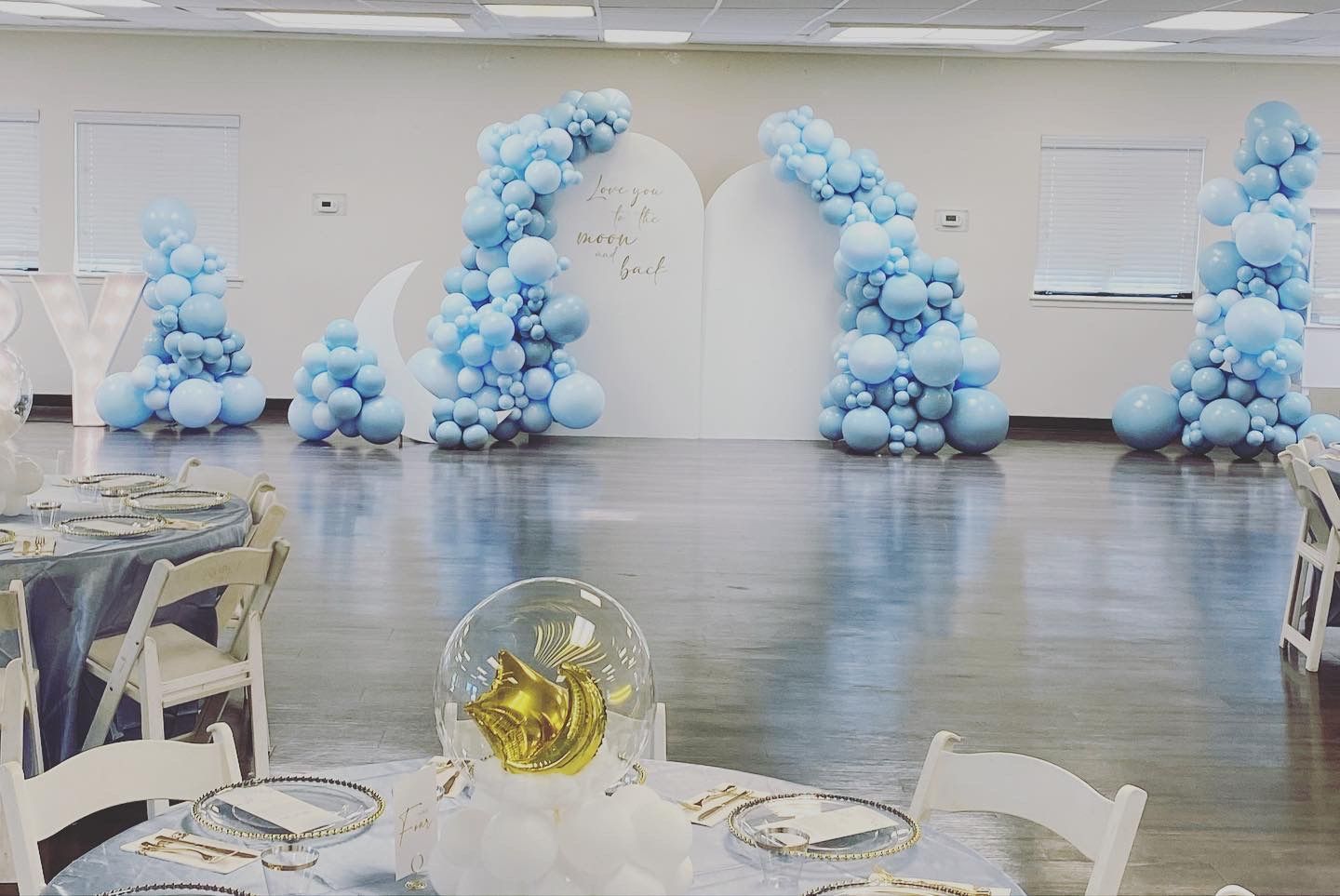 A room filled with tables and chairs and balloons.