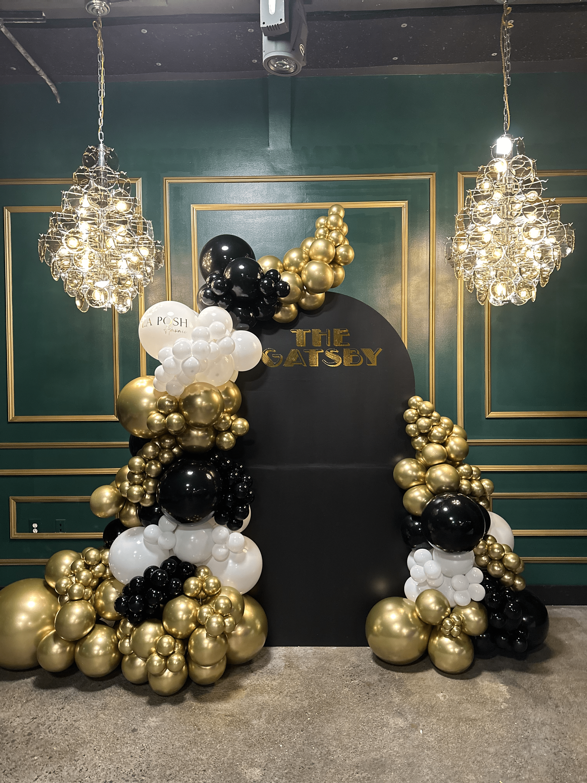 A bunch of balloons are sitting in front of a green wall.