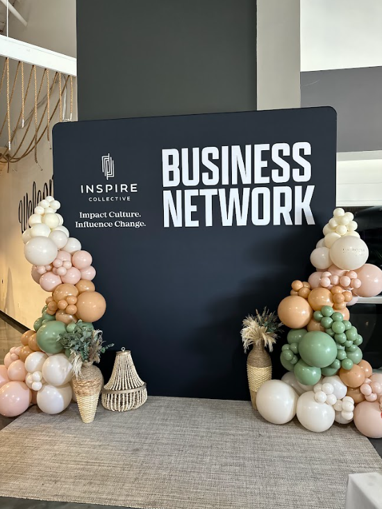 A sign that says business network is surrounded by balloons
