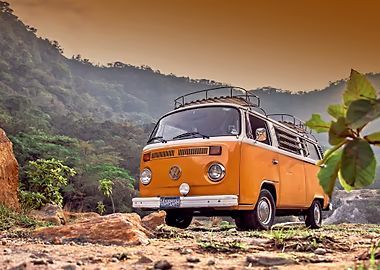 Yellow and white VW camper van parked on a dirt road in front of a mountainous landscape.