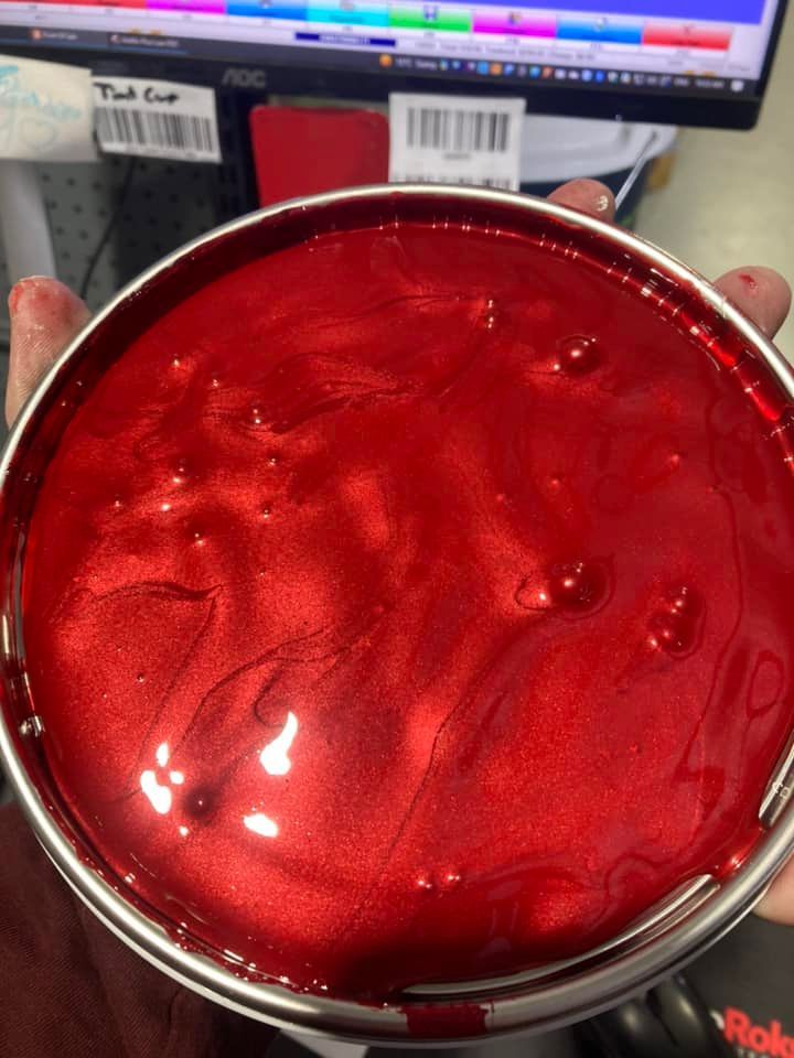 A Red Liquid-filled Metal Cup Held Over a Workbench — Paint Place Cowra in Orange, NSW